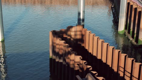 industrial shot of rusted sheet pile walls in a waterfront construction project surrounded by calm water on a sunny day