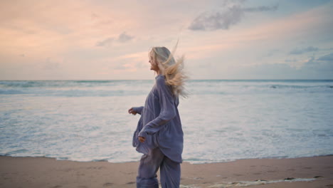 carefree woman running sunset ocean shore. happy smiling girl turning camera