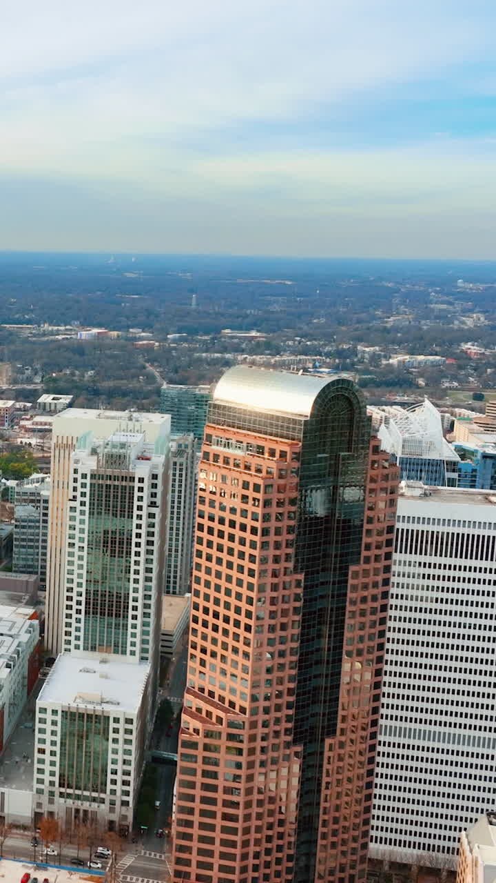 Vista panorâmica aérea do centro da cidade de Charlotte, Carolina do Norte, com um alto arranha-céu marrom do distrito financeiro. Vídeo vertical