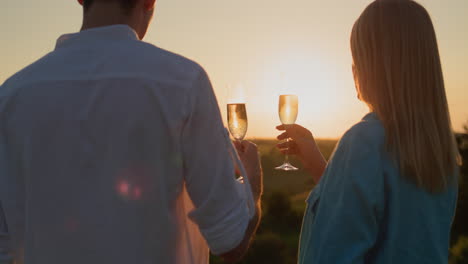 Ein-Paar-Mit-Einem-Glas-Rotwein-Beobachtet-Den-Sonnenuntergang-über-Einem-Malerischen-Tal.-4K-Video