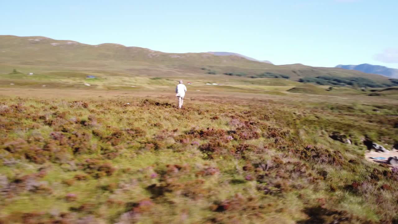 фотограф делает снимки на фоне зеленой долины и озера