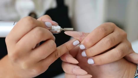 crop nail artist removing nail polish of customer in salon