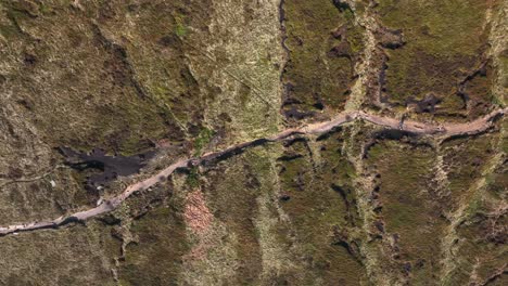 Dos-Excursionistas-Caminando-Por-Páramos-Salvajes,-Vista-Aérea-De-Drones