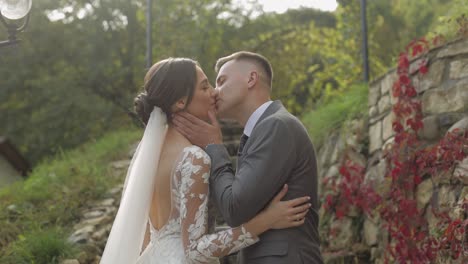 lovely newlyweds caucasian bride embracing groom in park making kiss, wedding couple family hugging