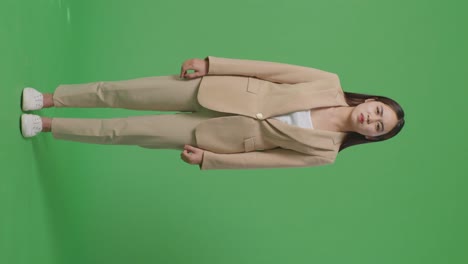 cuerpo lleno de mujer de negocios asiática no está satisfecha y sacude la cabeza mientras está de pie frente a la pantalla verde