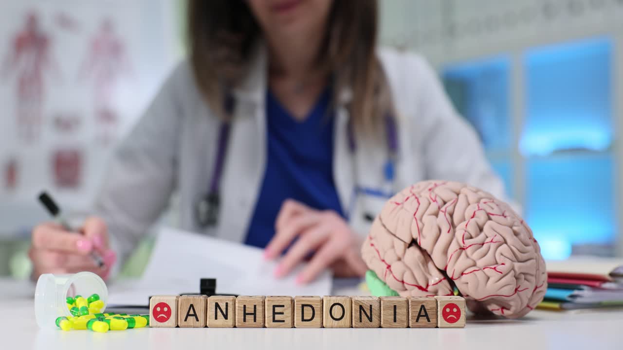 Palavra anedonia com pílulas e modelo de cérebro em hospital