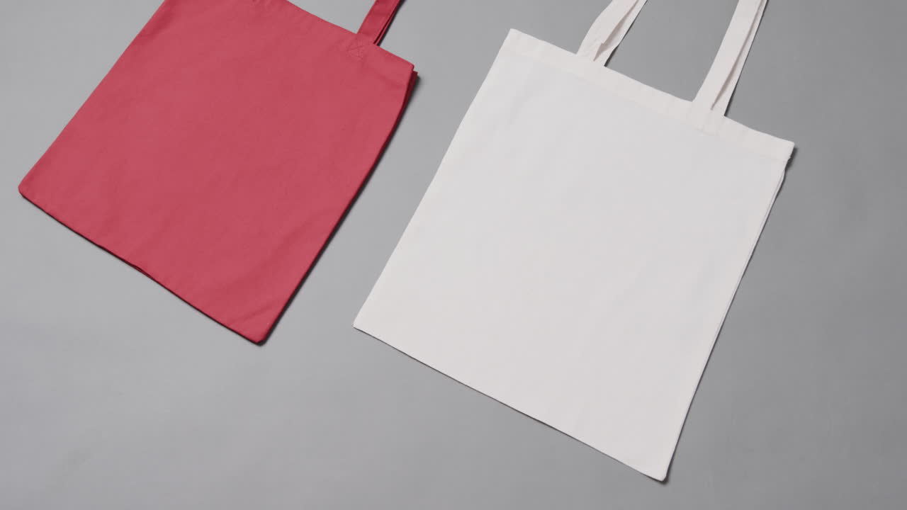 primer plano de bolsas rojas y blancas sobre fondo gris, con espacio de copia, cámara lenta