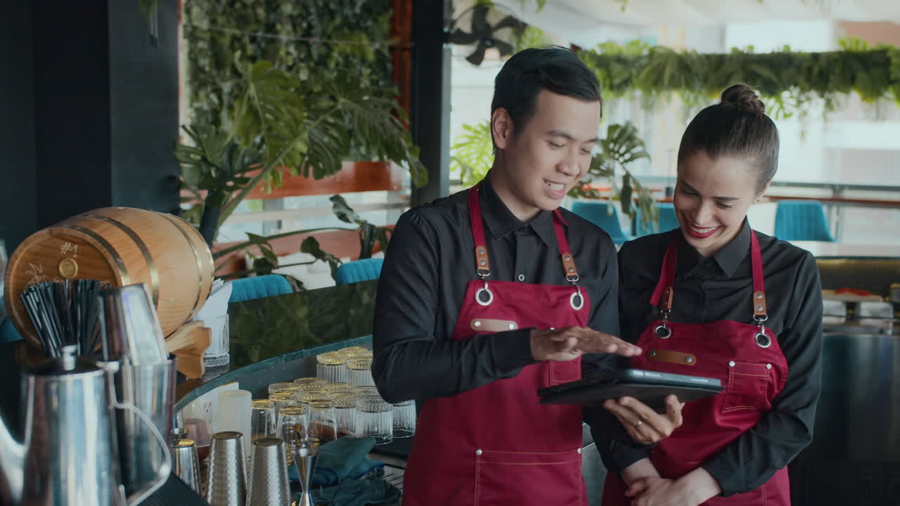 Bartender birasial Menggunakan Tablet PC saat Bekerja di Kafe