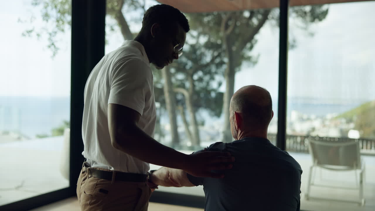 Physiotherapist Assisting Man with Shoulder Rehabilitation Exercise