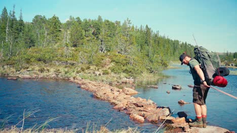 Male-Hiker-And-Alaskan-Malamute-Pet-Dog-Crossing-The-River-In-Indre-Fosen,-Norway---Wide-Shot