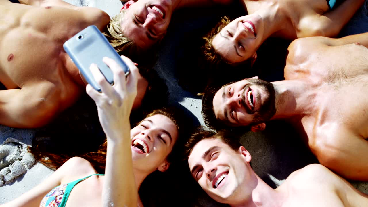 Grupo de amigos tomándose una selfie con el teléfono móvil
