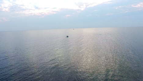 kayakista flotando en el mar en el cielo nocturno. vista de avión no tripulado hombre entrenando en kayak