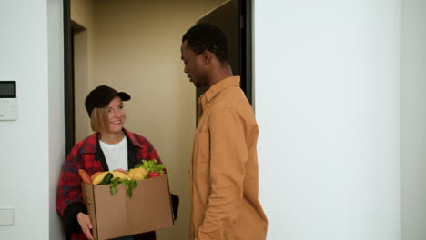 man receiving box of vegetables