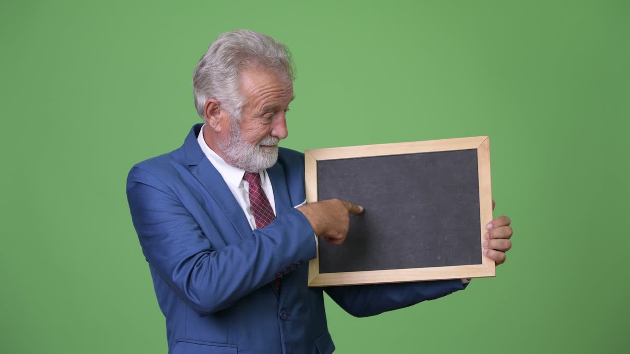 hombre de negocios barbudo y guapo contra un fondo verde.