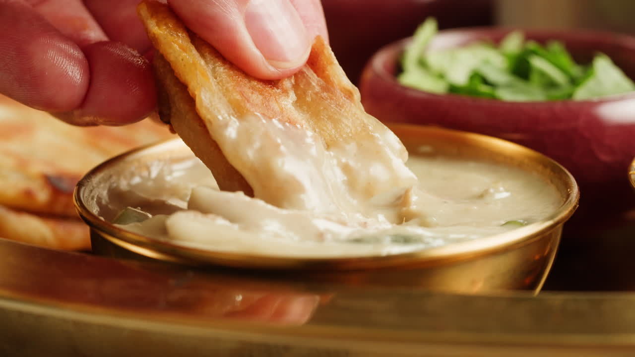 Assorted indian sri-lanka food set on wooden background. Dishes and appetisers of indeed cuisine, rice, lentils, paneer, samosa, spices, masala. Bowls and plates with indian food top view chicken. High quality 4k footage