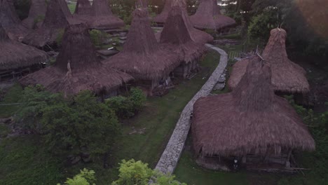 Tilt-up-shot-of-traditional-village-at-Sumba-Indonesia-during-sunrise,-aerial