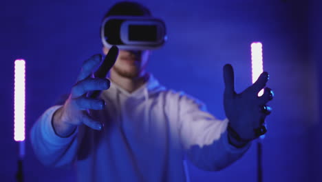 maschio che utilizza un auricolare vr su uno sfondo colorato di luci al neon 1