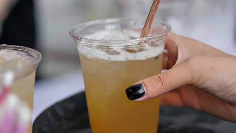 a girl picks up a disposable cup of drink, takes it out of the frame