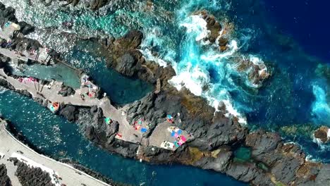 aerial drone footage of the natural pools of garachico caletón. blue ocean and the natural pools functioning as playas at tenerife. nice waves hit the rocks in the water.