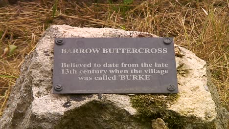 plaque describing the medieval butter cross in the middle of barrow village in the county of rutland in england, uk