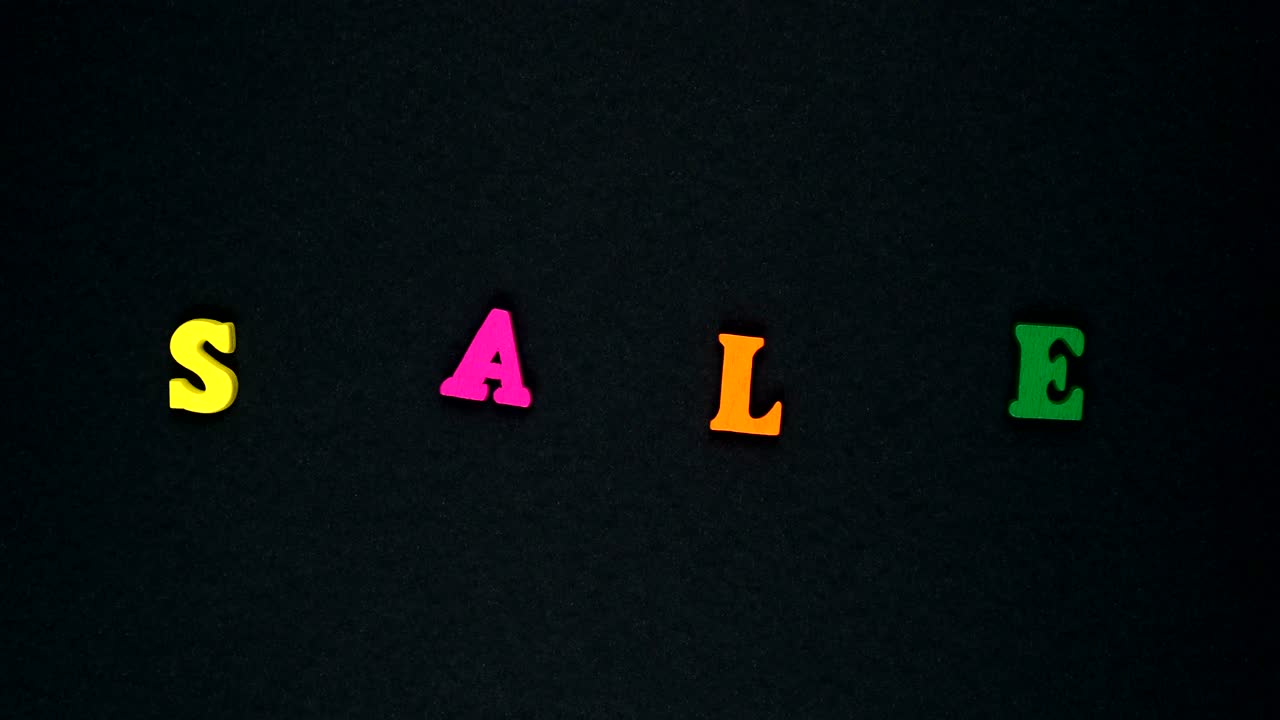 la palabra "venta" está formada por letras de madera multicolores. palabras coloridas en bucle.