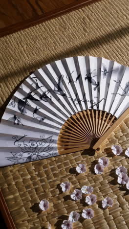 japanese fan and cherry blossoms on tatami mat