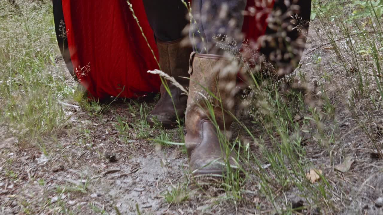 소름끼치는 저승사자 의상을 입은 사람의 다리와 광야를 걷는 갈색 가죽 부츠