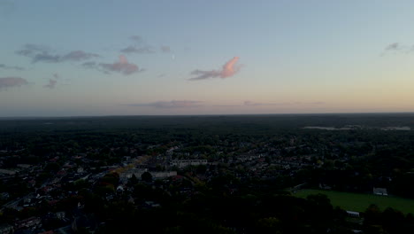 Antenne-Einer-Ruhigen-Kleinstadt-Mit-Sichtbarem-Mond-Am-Abendhimmel