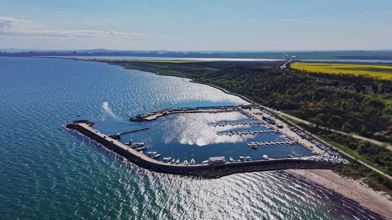 Naturskøn udsigt over marina og strand langs kysten på en solrig dag