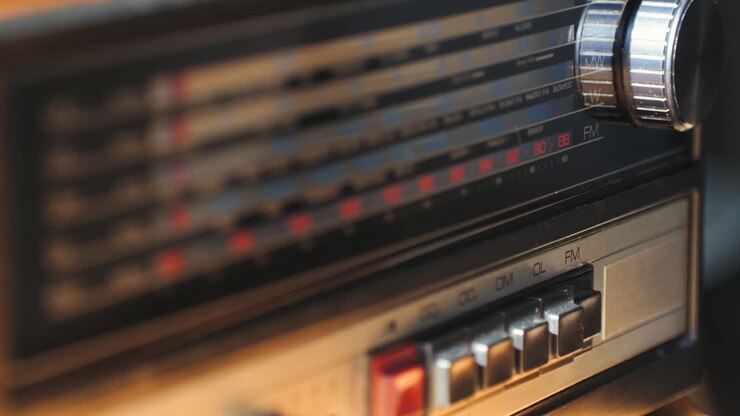 Vecchia radio AM FM retrò a valvole, mano che cambia stazione, lettore musicale vintage a valvole