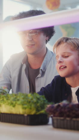 teacher and student observing microgreens in a classroom