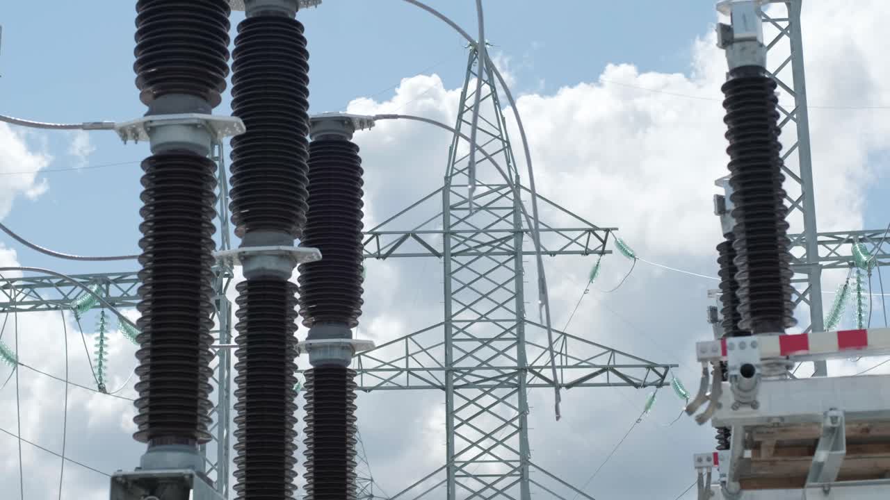 muchos aislantes eléctricos de alto voltaje en la subestación de energía contra un fondo de cielo azul