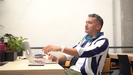 hombre alegre navegando por computadora portátil en la oficina