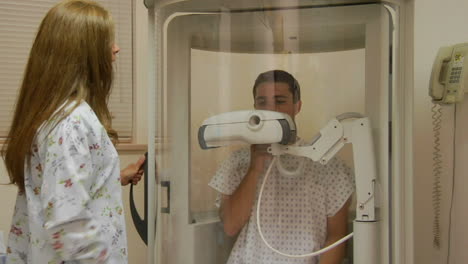 a nurse encloses a patient in a medical machine