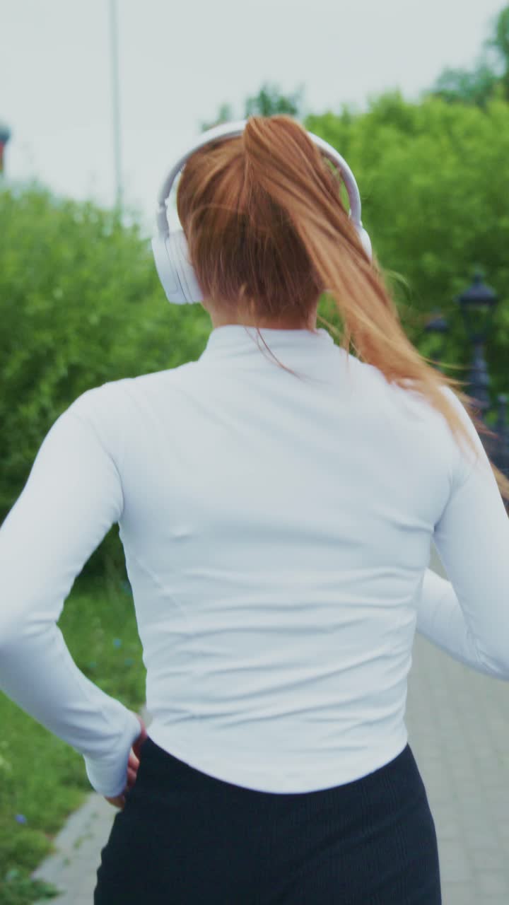 Energetic Woman Jogging in Nature with Headphones, Embracing Fitness and Rhythm as Her Hair Flows in the Wind on a Sunny Day
