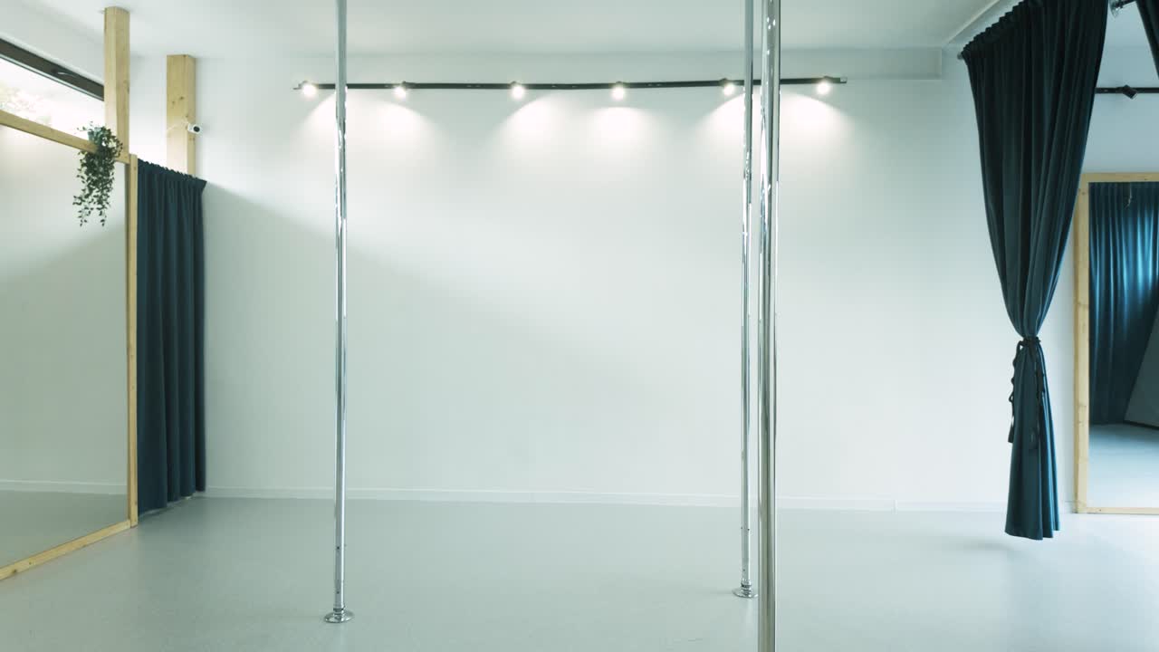 Elastic girl with long ponytail practicing Acro dance with pole dance bar