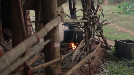 food cooking in metal pot over an open fire in outdoor wooden hut