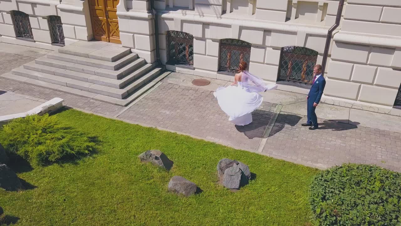 웨딩 드레스 를 입은 소녀 는 거리 에서 신랑 이 춤 을 추고 있다