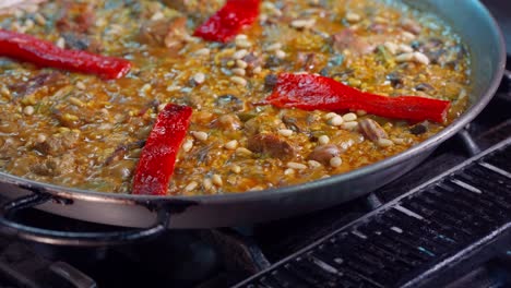 putting red peppers in spanish paella