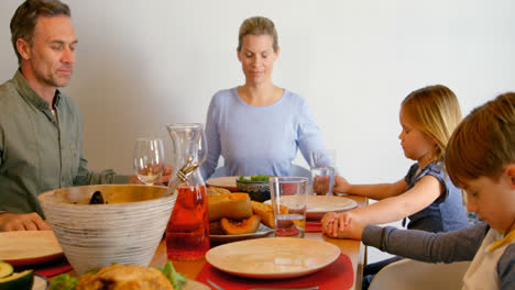 Front-view-of-Caucasian-family-praying-together-at-dining-table-in-a-comfortable-home-4k