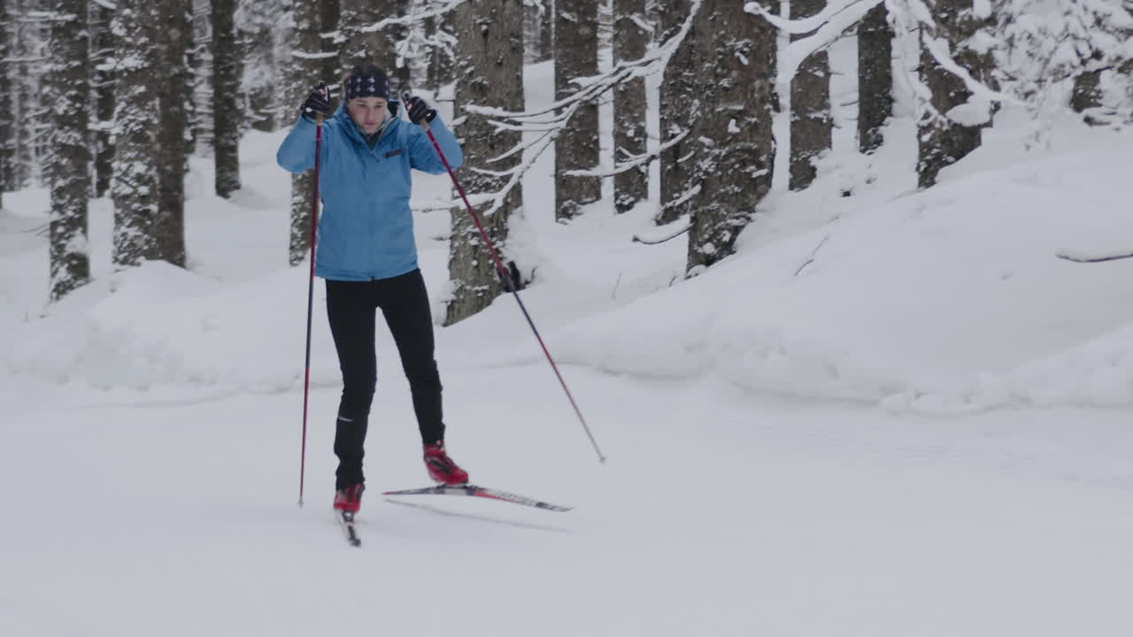 Donna che pratica sci di fondo in una foresta innevata