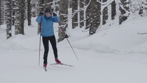 Woman Cross-Country Skiing in a Snowy Forest