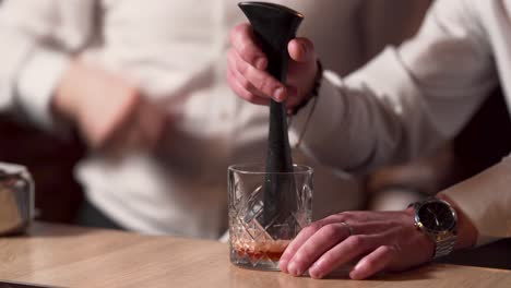 Close-up-shot-of-two-professional-bartenders-preparing-a-drink