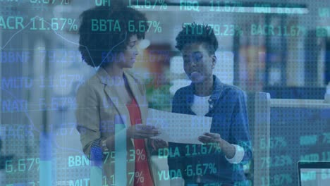 Animation-of-map-and-trading-board-over-diverse-female-coworkers-discussing-reports-on-desk