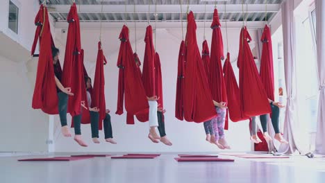 las mujeres practican en grupo la meditación de yoga anti-gravedad