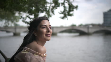 close up of an attractive latina tourist looking at river thames in london, slow motion shot