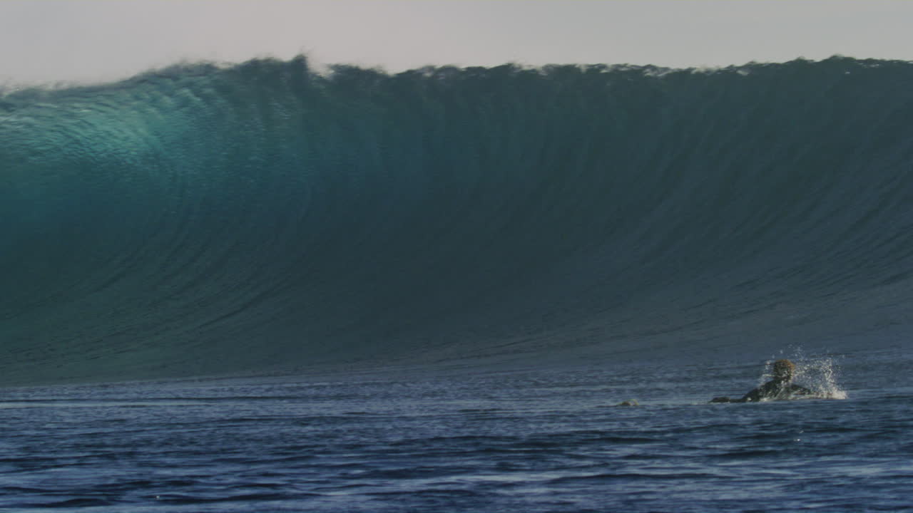 las paletas de los surfistas para salir de la zona de impacto como la ola en el rompimiento de nubes fiji se estrella brillando con niebla
