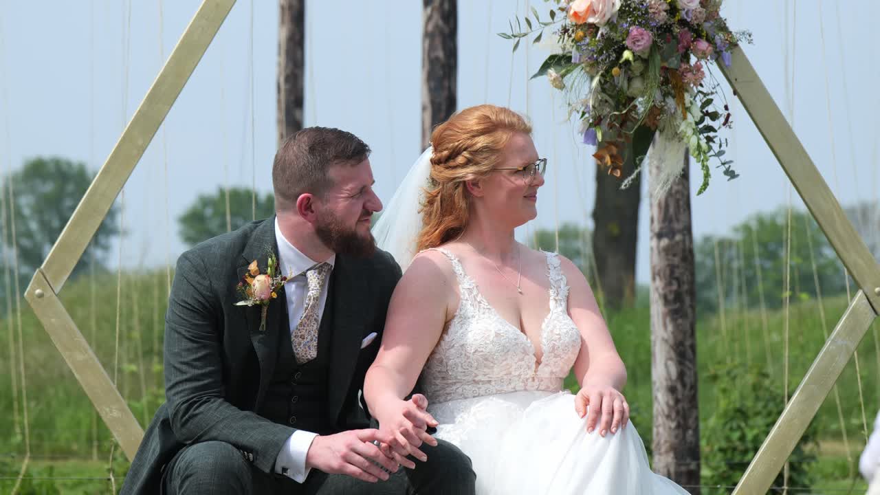 Bride and groom share a joyful moment outdoors on their wedding day