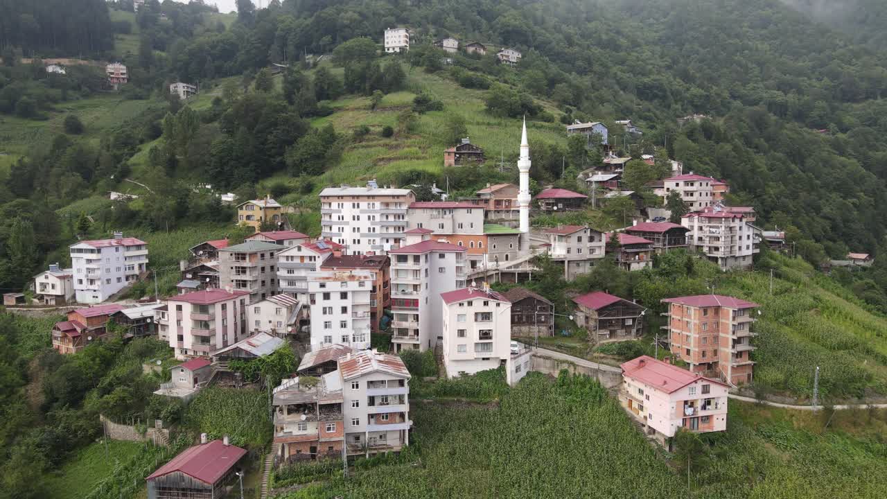Dağın eteğine kurulmuş kasabadaki cami minaresinin drone görüntüsü.