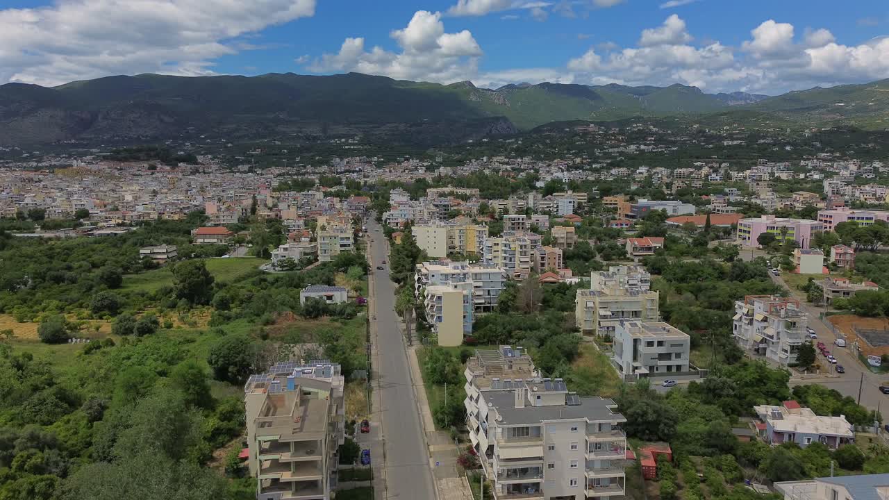 Aerial view of eastern suburbs of Kalamata city, high angle view of Iroon street, beautiful landscape on background, push in footage 4K
